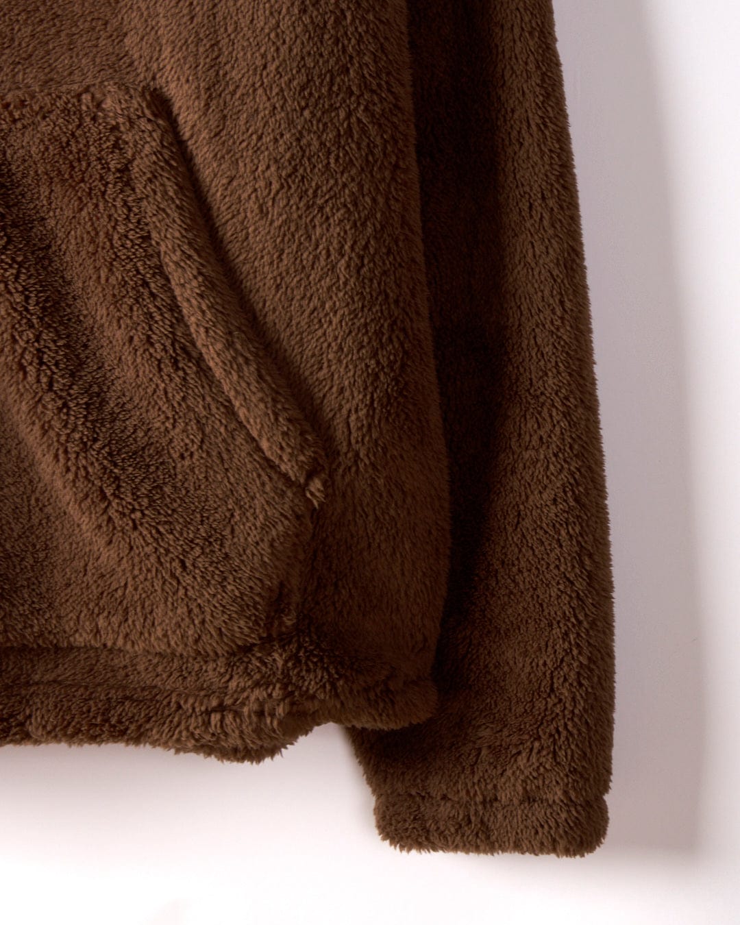 Close-up of the Arches - Mens Recycled Oversized Fleece in brown by Saltrock, highlighting one side pocket and sleeve against a white background.