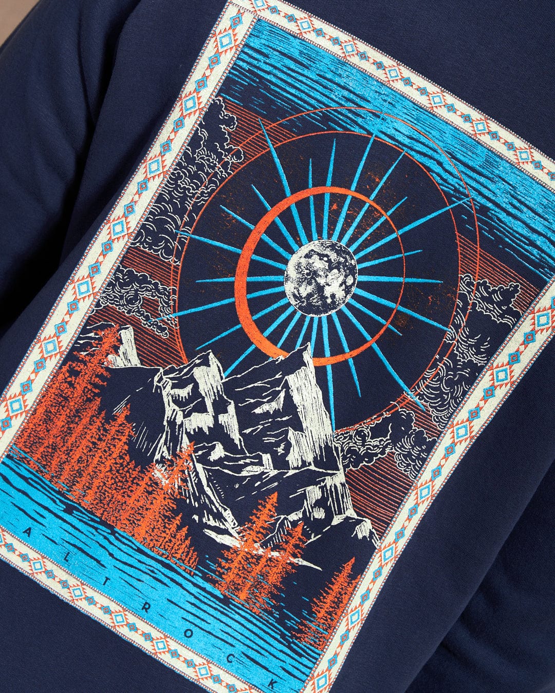 The Aztec Mountain Women's Zip Hoodie by Saltrock showcases a cosmic mountain scene with trees, a sunburst, and a moon on fabric. Geometric patterns on the border enhance its captivating aesthetic.