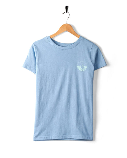 A light blue, 100% cotton t-shirt with short sleeves hangs on a wooden hanger, featuring a small, round, white Saltrock logo on the upper left chest area. This is the Saltrock Cold Water Club - Womens T-Shirt - Blue.
