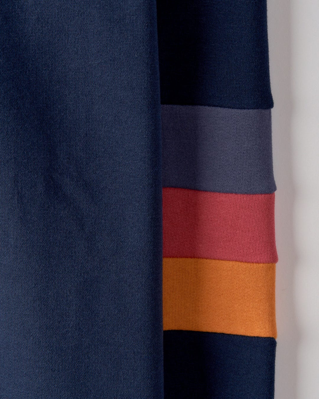 Close-up of Saltrock's "College - Womens Oversized Sweat - Blue" fabric strips in dark blue, gray, red, and orange colors stacked vertically from top to bottom. The retro stripes evoke a nostalgic feel reminiscent of Southwest 1988.