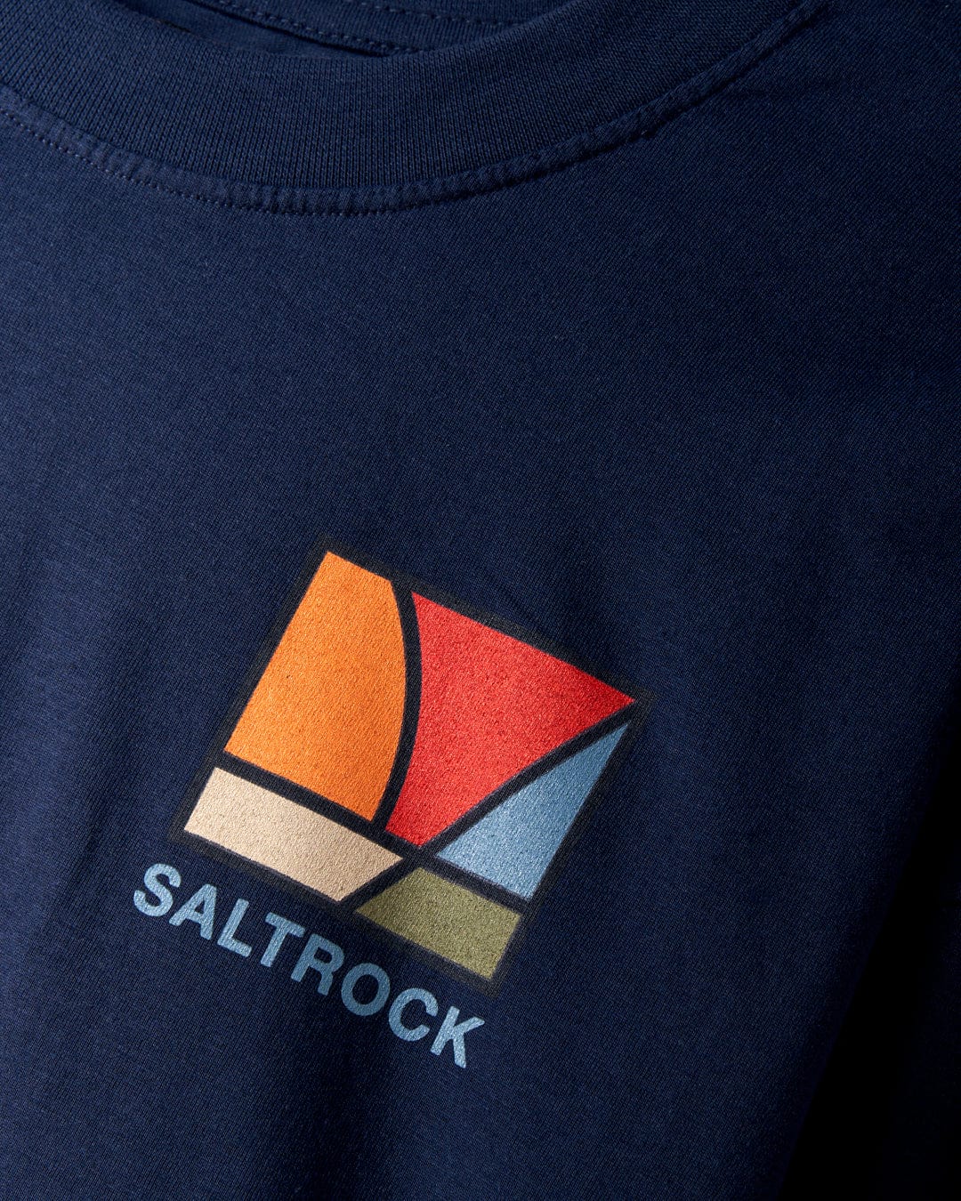 Introducing the Dimensions Colour 2 - Mens Long Sleeve T-Shirt in Blue by Saltrock, a navy blue top crafted from 100% cotton. It features a vibrant geometric sunrise prism graphic with the word "Saltrock" elegantly printed underneath.