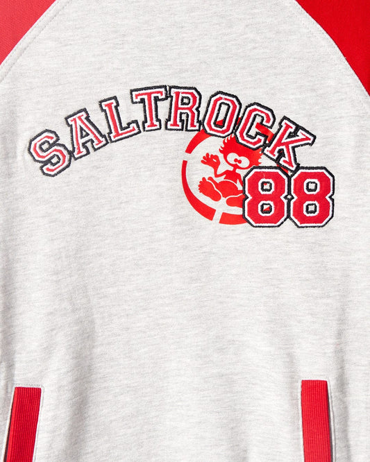 A close-up of a grey sweatshirt with red raglan sleeves, displaying the word "Saltrock" and the number "88" in red and black, along with a red graphic of a koala. The product is called Drop Out - Kids Sweat Shirt - Grey/Red by Saltrock.