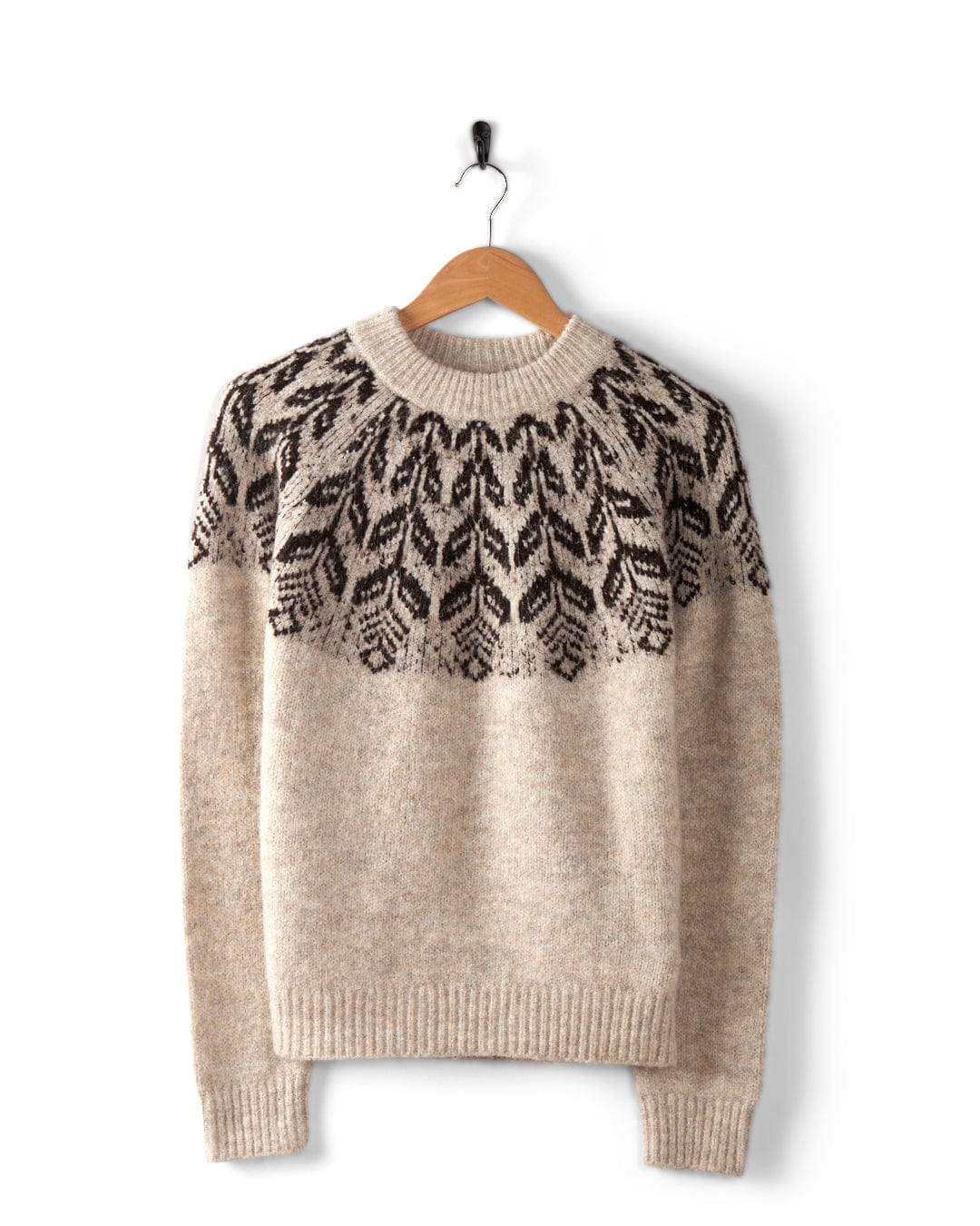 The Saltrock Fairisle Women's Knitted Jumper showcases a cream color with a crewneck design and features an elegant dark brown geometric pattern around the yoke, displayed beautifully on a wooden hanger.