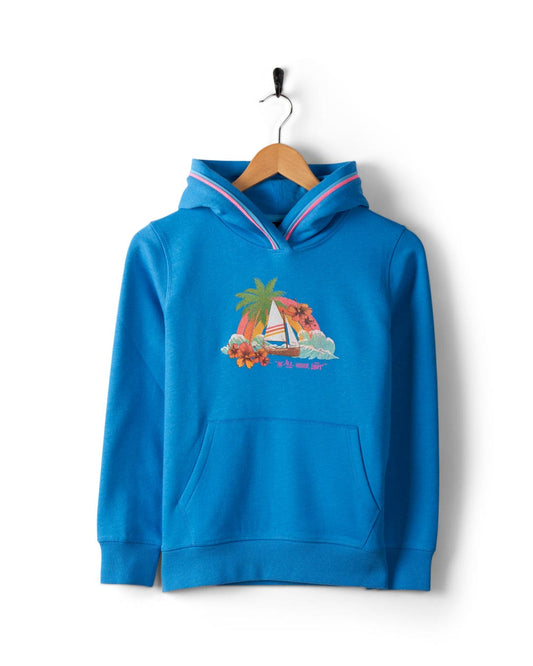 A Floral Lost Ships - Kids Recycled Pop Hoodie - Blue with a front pouch, featuring Lost Ships graphics of a sailboat, palm tree, and flowers from Saltrock. Made from recycled materials, the hoodie hangs on a wooden hanger against a white background.