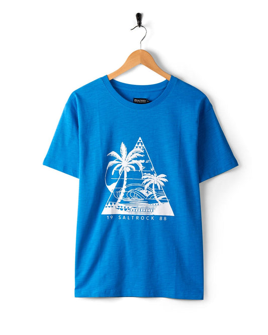 Blue t-shirt with white palm tree and beach graphic, titled "Geo Beach Mono - Women's T-Shirt - Blue," featuring classic Saltrock branding, hanging on a wooden hanger against a white background. Made from 100% cotton.
