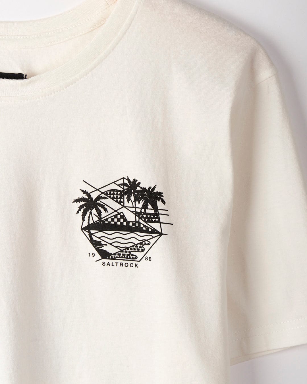 The Geo Palms - Mens T-Shirt - White, featuring Saltrock graphics with a black hexagonal design showcasing palm trees, ocean waves, a sun, and the text "Saltrock 1988," is made from 100% cotton for ultimate comfort.
