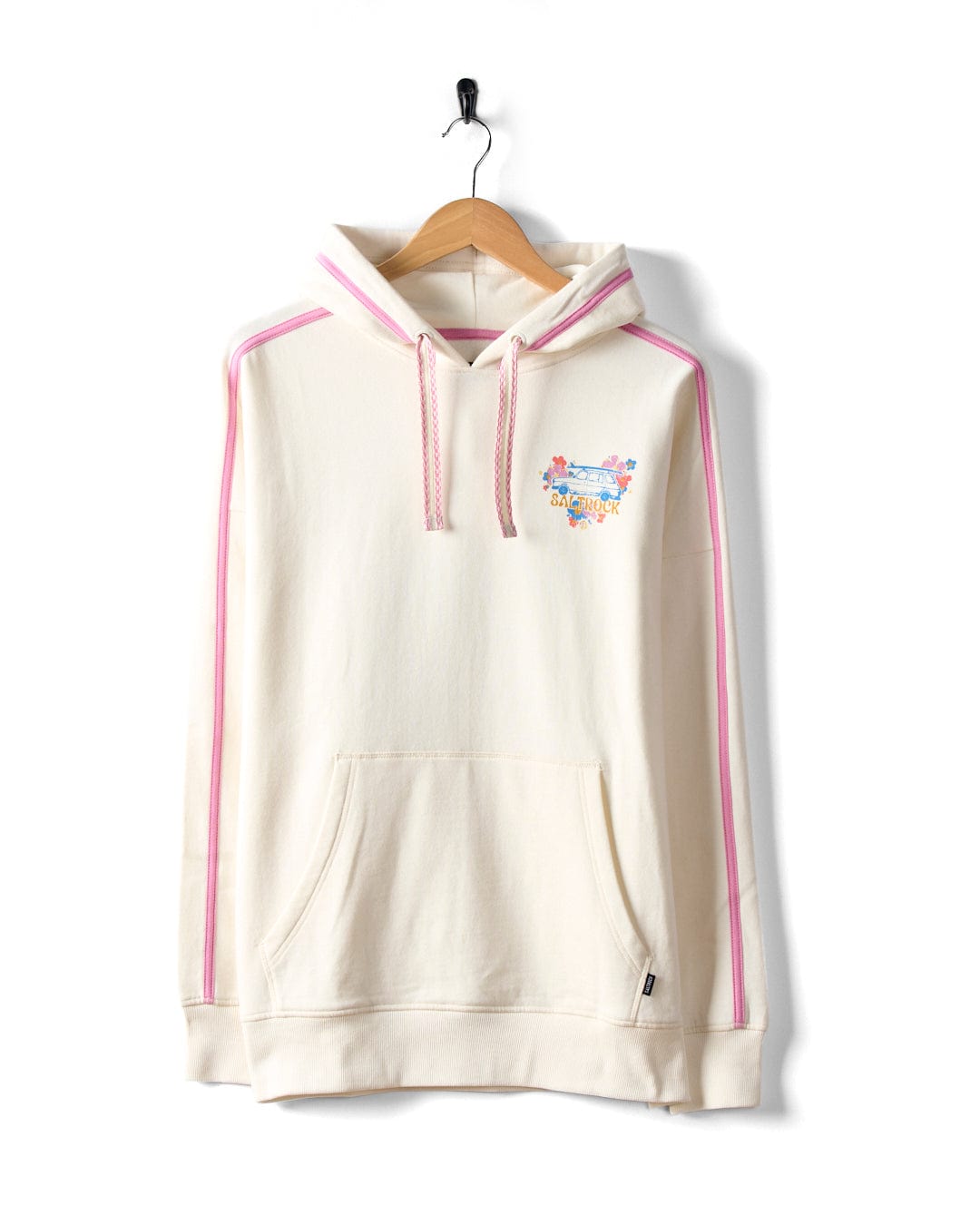 Displayed on a wooden hanger, the Saltrock Highway women's pop hoodie in cream is crafted from soft cotton. It features pink-striped sleeves, a front pocket, and a small colorful graphic on the chest.