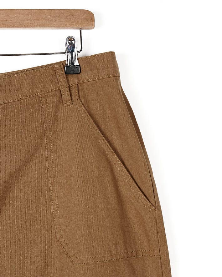 A pair of Hilda Twill - Womens Trouser - Light Brown pants hanging on a hanger. (Saltrock)