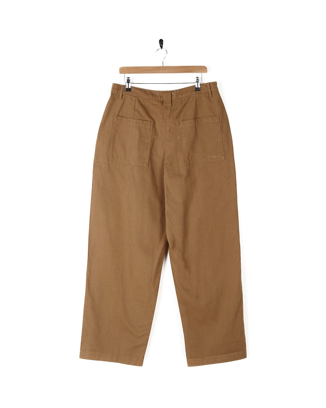 A pair of Saltrock Hilda Twill - Womens Trouser - Light Brown pants hanging on a hanger.