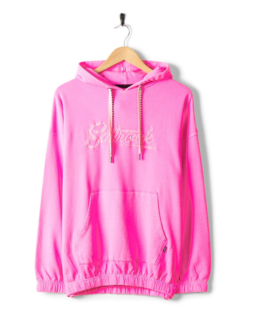 Bright pink Instow - Womens Pop Hoodie - Pink with "Saltrock" embroidered across the chest, hanging on a wooden hanger against a white background. This 100% cotton garment features a front pocket and drawstring hood, perfect for cozy days.