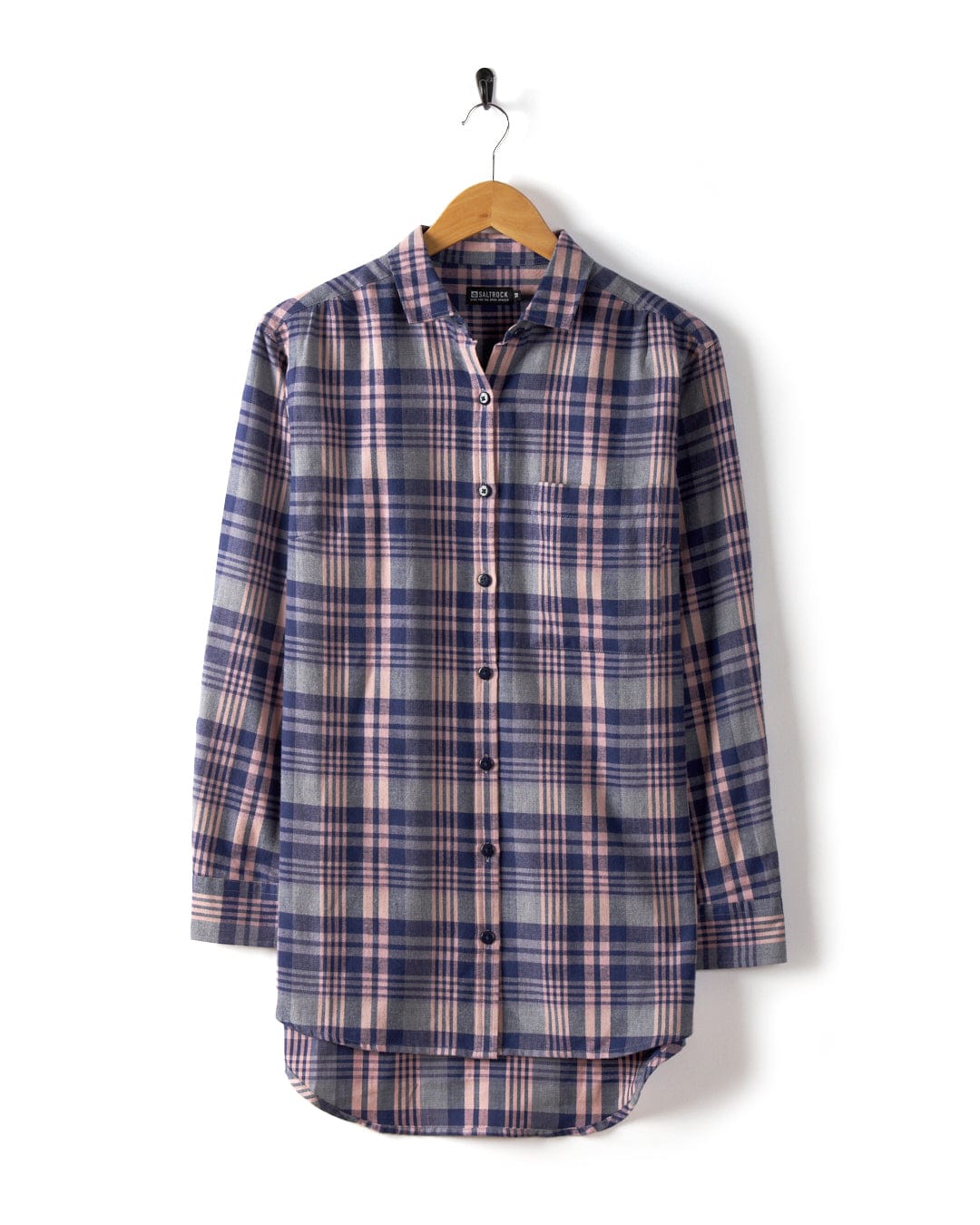 A purple plaid longline shirt from Saltrock, crafted from 100% cotton with a button-up front and long sleeves, is displayed elegantly on a wooden hanger against a pristine white background.