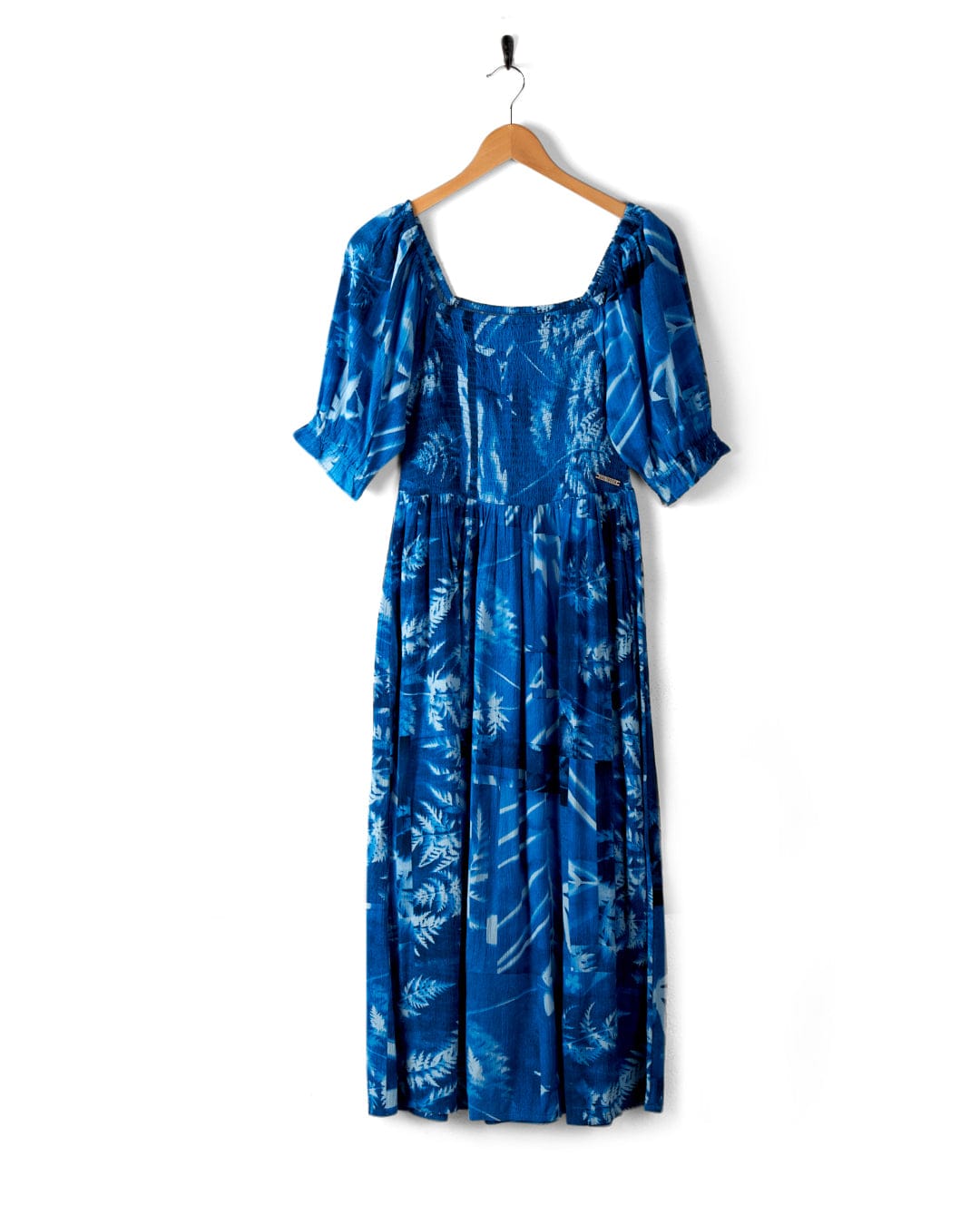 A Larran Cyanotype - Midi Woven Dress - Blue by Saltrock with short sleeves and a square neckline, hanging on a wooden hanger against a white background.