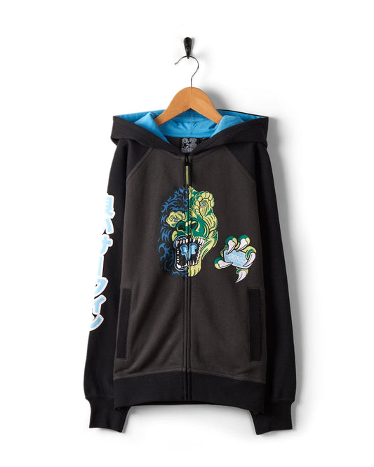 Las Vegas Smackdown - Recycled Oversized Kids Zip Hoodie - Black by Saltrock with a colorful snarling gorilla graphic on the front, blue lining on the hood, and a green claw design on the left arm, hanging on a wooden hanger. This oversized fit also features glow-in-the-dark graphics for an extra touch of flair.