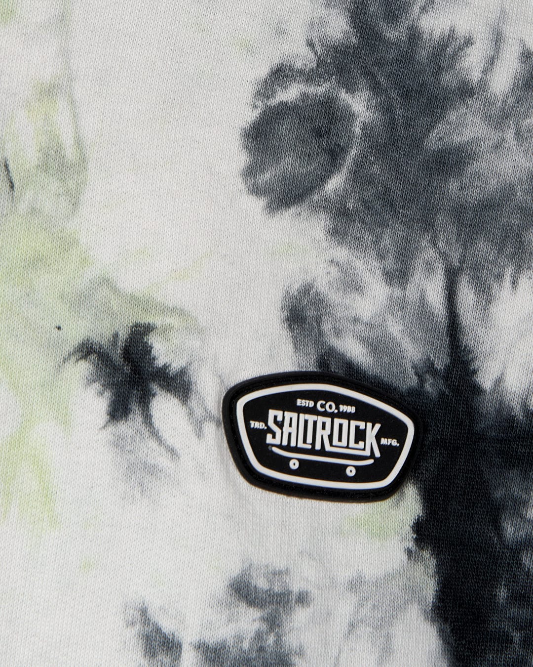 Black and white tie-dye fabric with a small "Saltrock" patch featuring text "ESTD CO. 1993" on the lower right, complemented by a cozy kangaroo pocket. The product is the Las Vegas Smackdown - Kids Glow in the Dark Oversized Pop Hoodie - Multi from Saltrock.