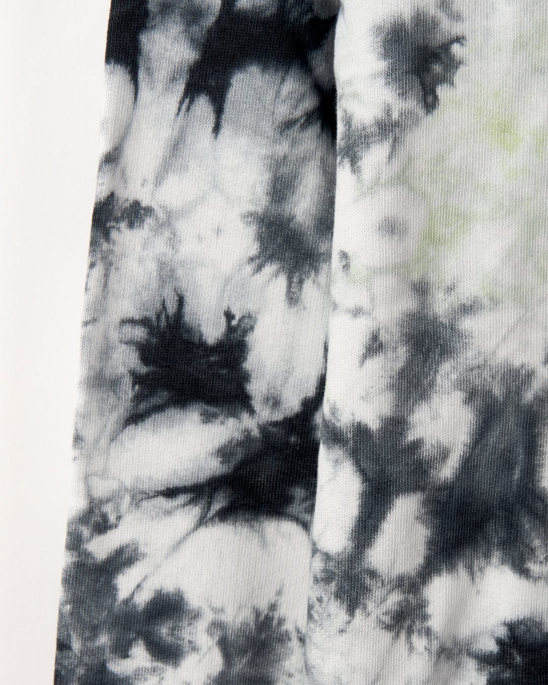 Close-up of a fabric with a black and white tie-dye pattern showing uneven and abstract shapes, complemented by subtle glow in the dark graphics of the Saltrock Las Vegas Smackdown - Kids Glow in the Dark Oversized Pop Hoodie - Multi.
