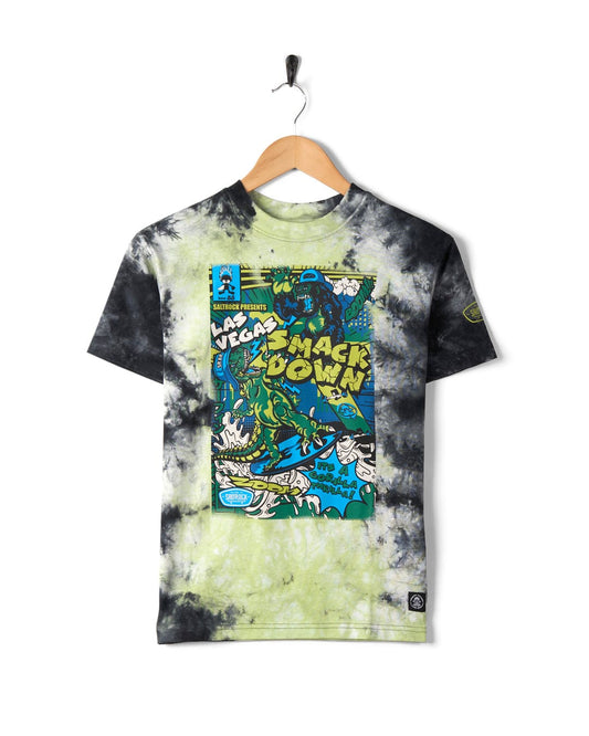 A Saltrock Las Vegas Smackdown - Kids Glow in the Dark T-Shirt - Multi, featuring a wrestling scene in black, green, and blue tones, and glow in the dark graphics, hanging on a wooden hanger.