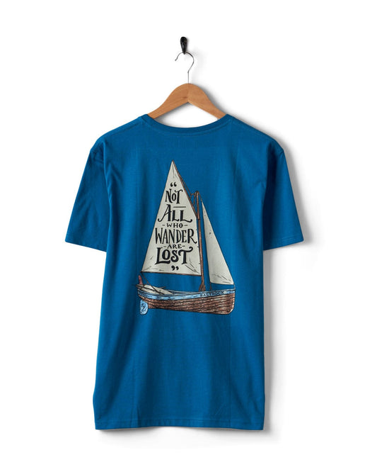 The Saltrock classic "Lost Ships" men's blue short sleeve T-shirt features a sailboat graphic and the quote "Not all who wander are lost" on the back. Made from 100% cotton, it embodies endless wanderings.