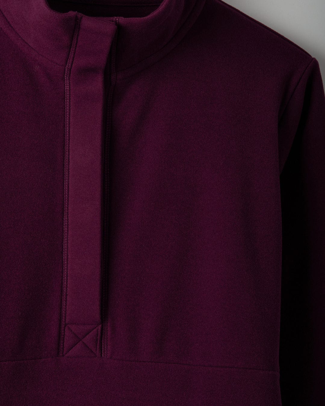 Close-up of the burgundy Morgan women's 1/4 neck longline fleece by Saltrock, featuring a high funnel neck and a quarter-length front zipper.