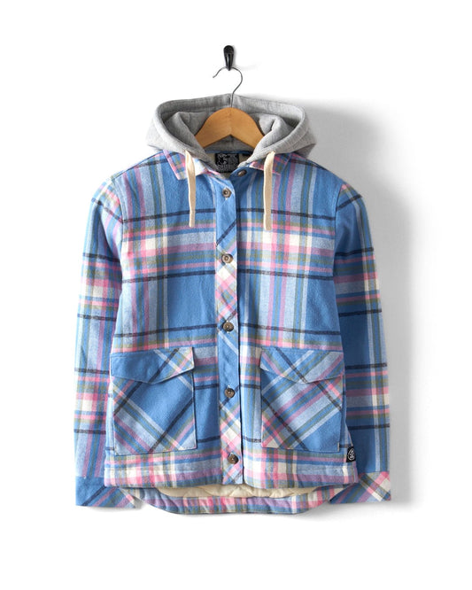 The Myla Kids Hooded Shacket by Saltrock features a blue and pink plaid design, a detachable grey hood, button front, and two large pockets. It hangs elegantly on a wooden hanger against a white background.