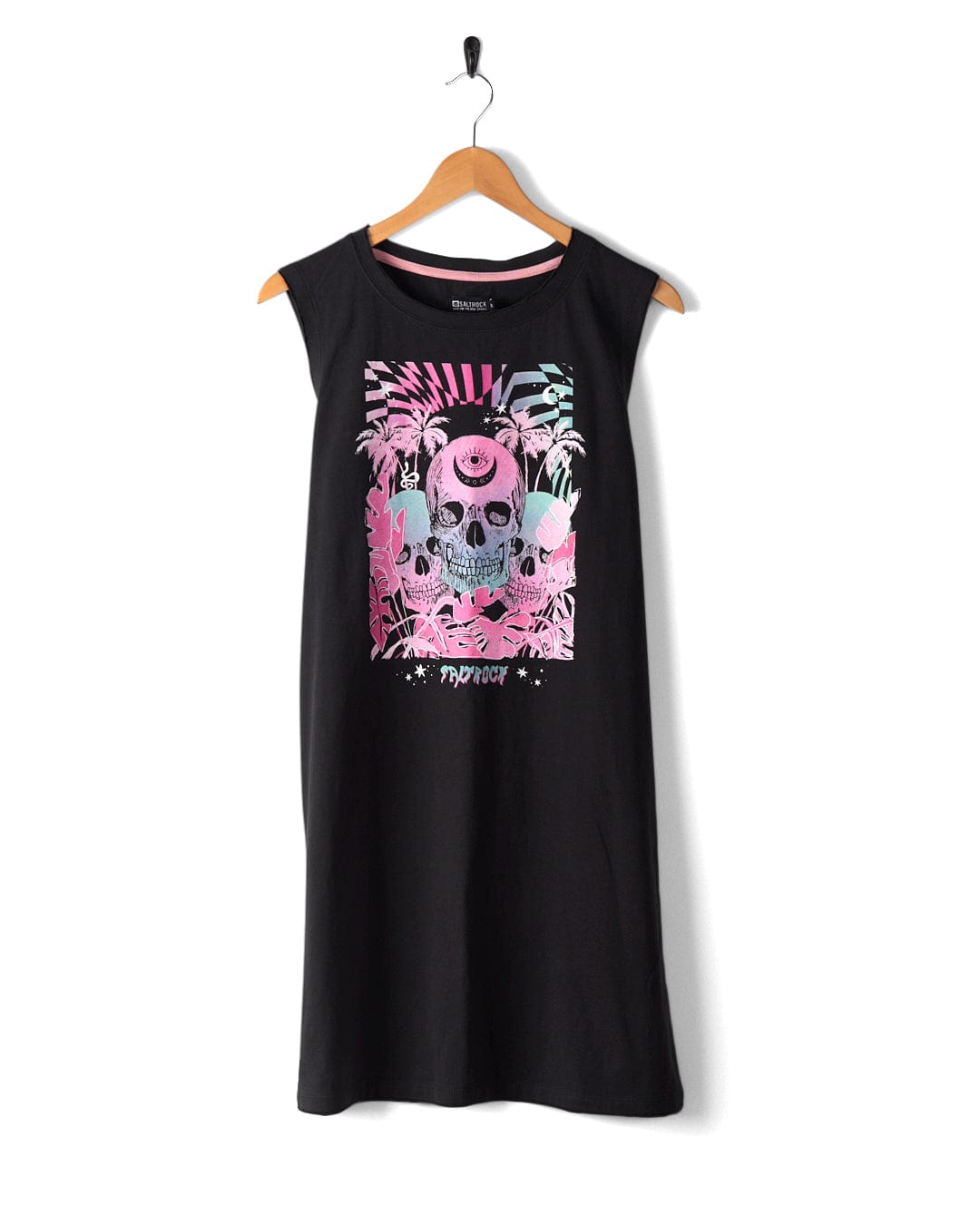 A Saltrock Mystic Skulls women's jersey vest midi dress, in black and made from 100% cotton, features a multicolored neon warped skull illustration accompanied by plants and the word "Reverie" at the bottom. It hangs on a wooden hanger against a white background.