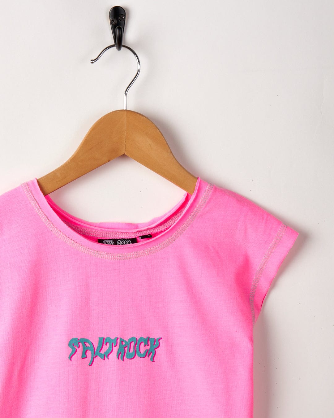 A pink sleeveless vest with the word "MYROCK" in teal, hanging on a wooden hanger against a white background. 
Replace with:
A Mystic Skulls - Recycled Kids Longline Vest - Pink with the word "Saltrock" in teal, hanging on a wooden hanger against a white background.