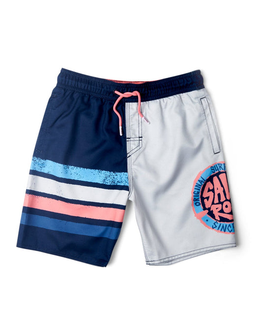 A pair of color-block swim trunks with one navy side featuring pink and blue stripes and a grey side with a pink graphic that reads "Original Surf San Diego." The design is completed with an elasticated waist, Saltrock branding, and branded dipped rubber end drawstrings in pink.
