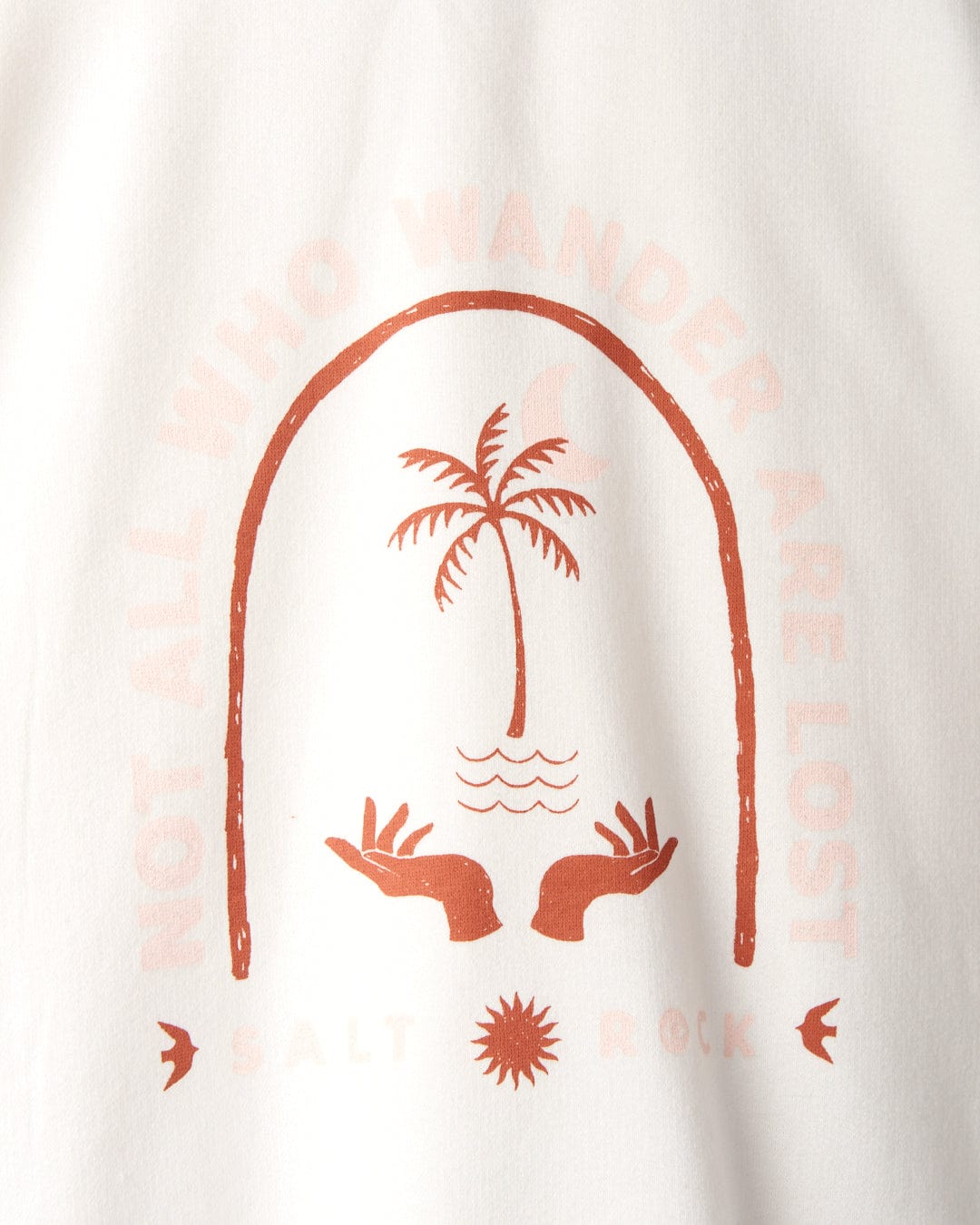 Illustration of a palm tree within an arch, flanked by two outstretched hands. The phrase "Not All Who Wander Are Lost" encircles the design, with "Salt Rock" below it. Perfect for your new 100% cotton Saltrock Palmera - Womens Pop Hoodie - Cream with a cozy contrast hood.