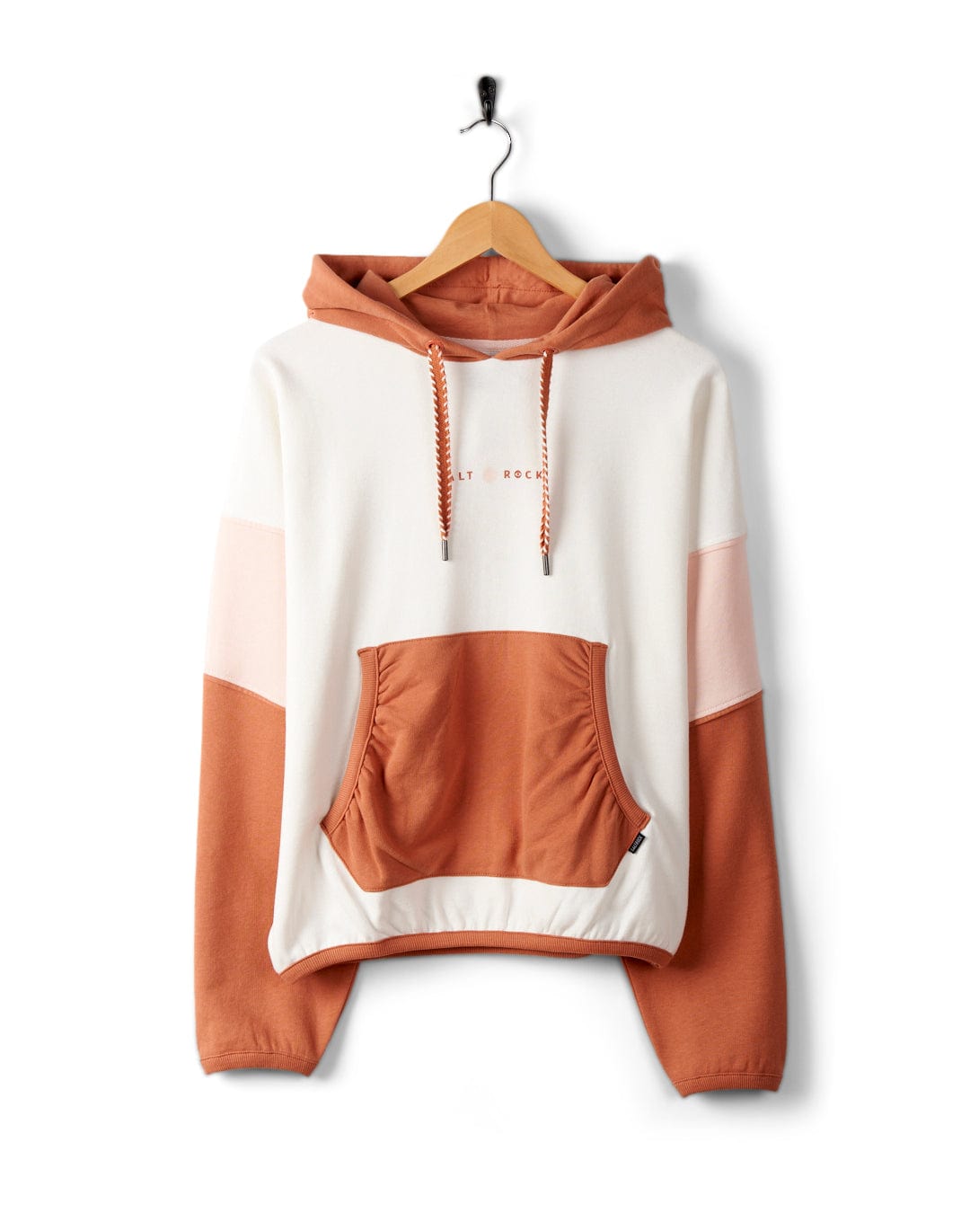 A Palmera - Womens Pop Hoodie - Cream with white, pink, and brown sections, featuring Saltrock branding, a front pouch pocket, and a drawstring at the hood. Made from cozy cotton for a loose fit, it hangs on a wooden hanger.