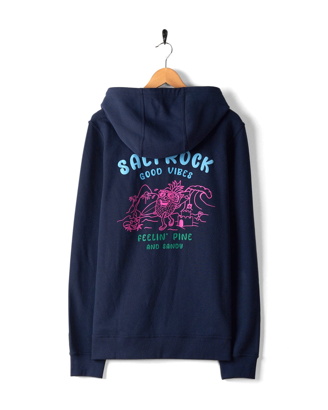 A navy blue hoodie with a vibrant graphic on the back, showcasing beach imagery and the text "Salt Rock Good Vibes Feelin' Pine and Sandy." The Saltrock hoodie, named "Pine And Sandy - Mens Recycled Zip Hoodie - Blue," is crafted from recycled materials and highlights Saltrock branding. This machine washable hoodie is displayed on a wooden hanger.