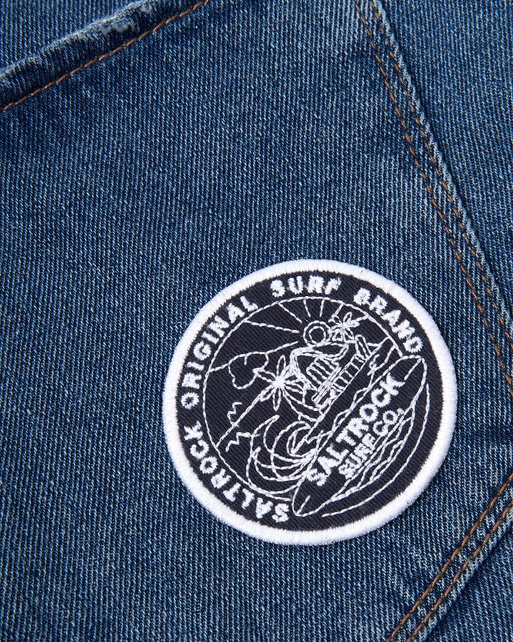 The pocket of a blue denim jacket has a Saltrock Retreat Patch - Navy on it.