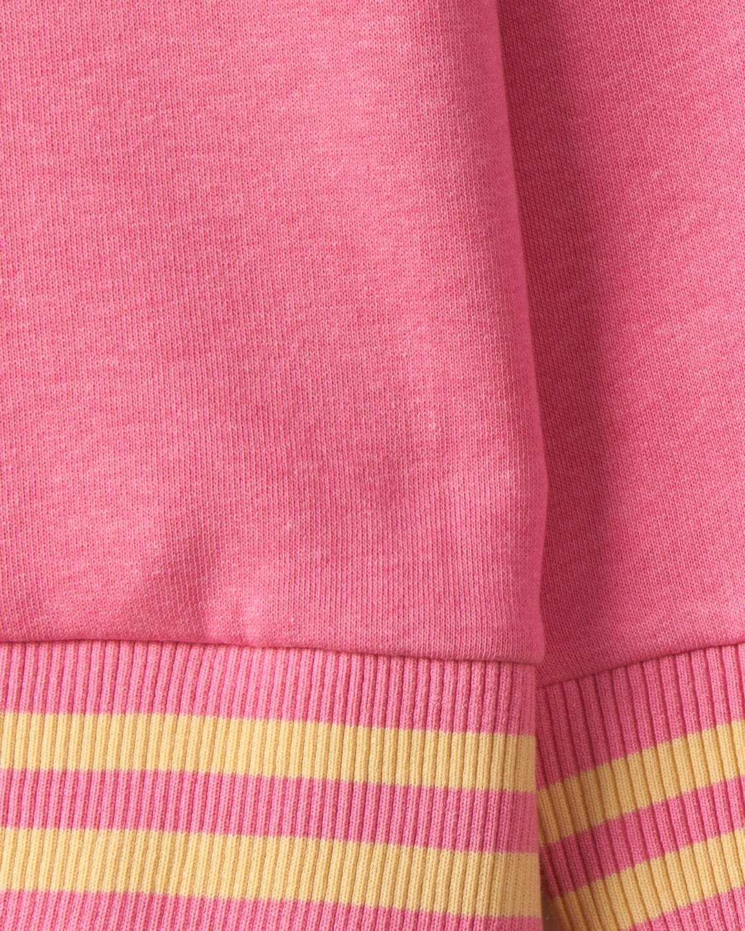 Close-up of a pink fabric with ribbed cuffs featuring yellow and pink stripes, adorned with subtle Saltrock branding. This is the Retro Seascape - Recycled Kids Longline Pop Hoodie - Pink by Saltrock.