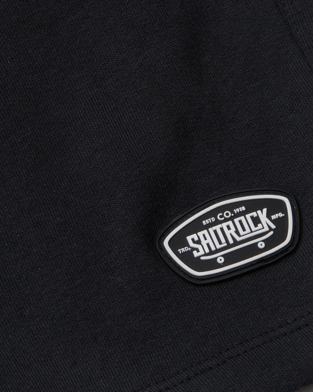 A close up of a Saltrock black Rip It - Kids Sweatshort t-shirt with a logo.