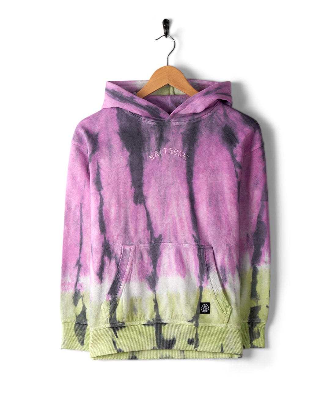 A 100% cotton tie-dye hoodie in shades of purple, black, and green hangs on a wooden hanger against a white background. The Rock Valley - Pop Hoodie - Multi by Saltrock features a front pocket, Saltrock branding, and a small label at the bottom.
