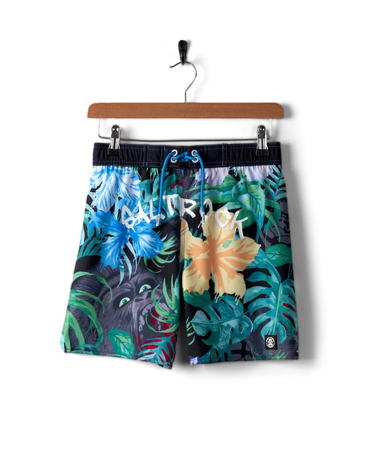 The Saltrock Rumble - Kids Recycled Boardshorts - Multi, with a tropical floral pattern and drawstring waist, made from recycled material with 4-way stretch, hung on a wooden hanger.