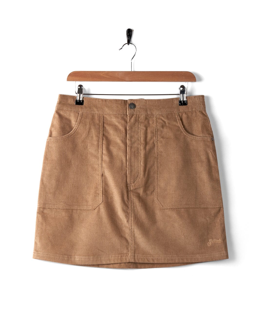 The Sadie women's cord skirt by Saltrock in brown hangs elegantly on a hanger against a pristine white background.