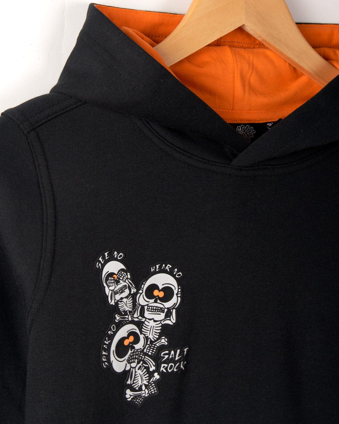 Black hoodie with a "See no evil, hear no evil, speak no evil" design featuring three skeletons. The inside of the hood is orange. The word "Saltrock" is printed at the bottom of the design. Features a convenient kangaroo pocket for easy storage.
Product Name: See No Skulls - Kids Recycled Pop Hoodie - Black
Brand Name: Saltrock