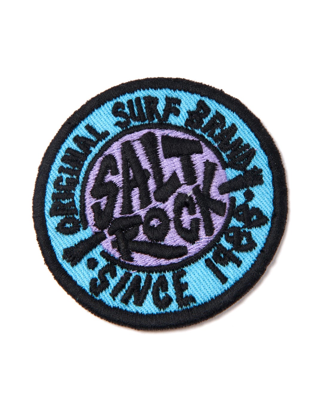 Circular iron-on embroidered patch featuring the text "salt rocks" and "original surf brand since 1973" in a stylized font, with a black background and blue and white detailing from Saltrock's SR Original - Patches - Blue.