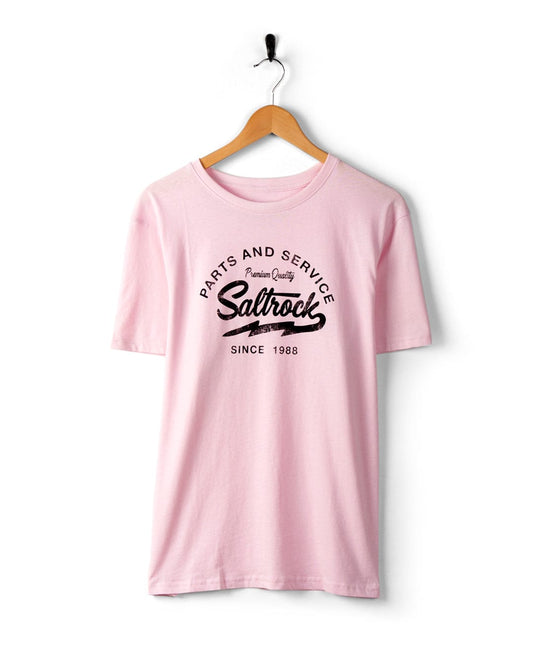 Strike Logo - Mens T-Shirt - Pink with black text, "Parts and Service," "Saltrock," and "Since 1988," hanging on a wooden hanger against a white background, showcasing classic Saltrock branding.