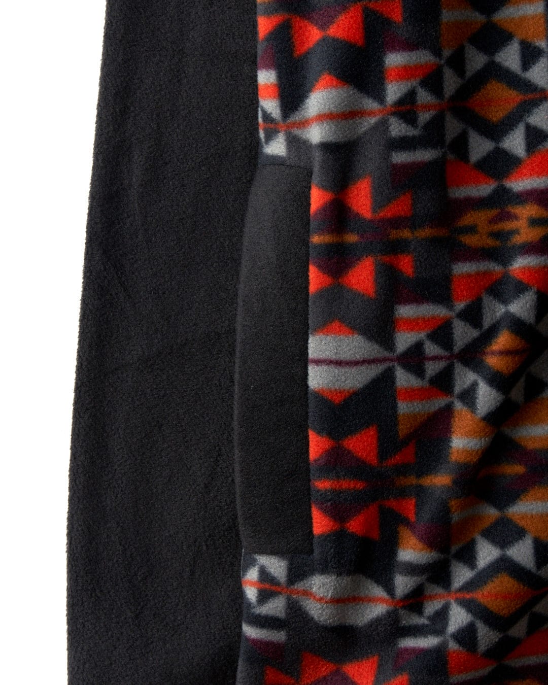 Close-up of the Saltrock Theo Wilds Men's Recycled Microfleece in black, featuring a patterned flap with a red, gray, and orange geometric print.