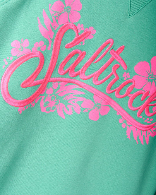 Green fabric featuring the word "Saltrock" in pink cursive letters, surrounded by pink floral designs. This 100% cotton piece, known as the "Tropic - Womens Sweat - Green," is not only stylish with its Saltrock branding but also practical, being machine washable for easy care.