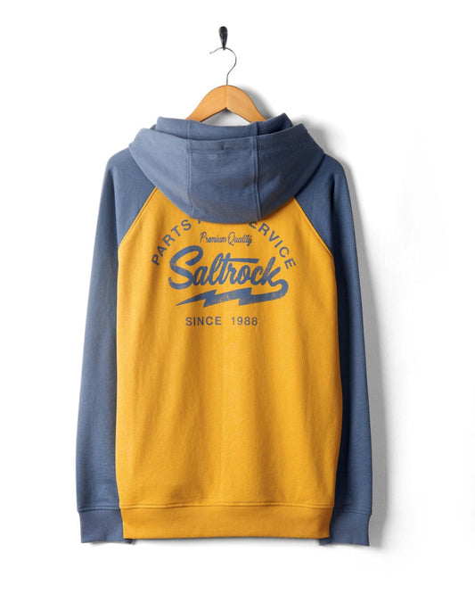 A blue and yellow hoodie with contrast raglan sleeves and the words "Saltrock Party & Service Since 1988 Premium Quality" on the back, hanging on a wooden hanger against a white background. The Vegas Script - Mens Pop Raglan Hoodie - Yellow features Saltrock embroidery and a drawstring hood for added style.