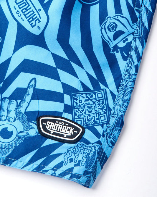 Close-up of a blue fabric with various intricate designs, including a QR code, hands making gestures, and a patch labeled "Warp Icon - Kids Swimshorts - Blue." The material features an elasticated waist and mesh lining that adds both comfort and style.