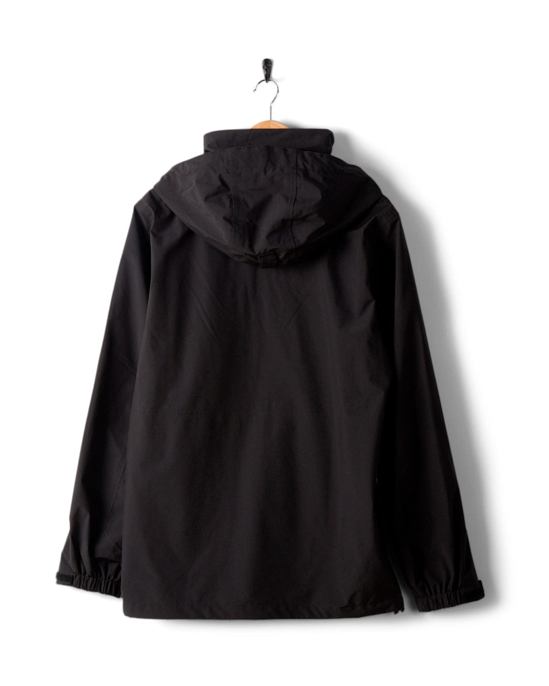 The Saltrock Whistler II Men's Waterproof Hooded Jacket in black, featuring a sleek design and breathable fabric, is displayed on a wooden hanger against a pristine white background.