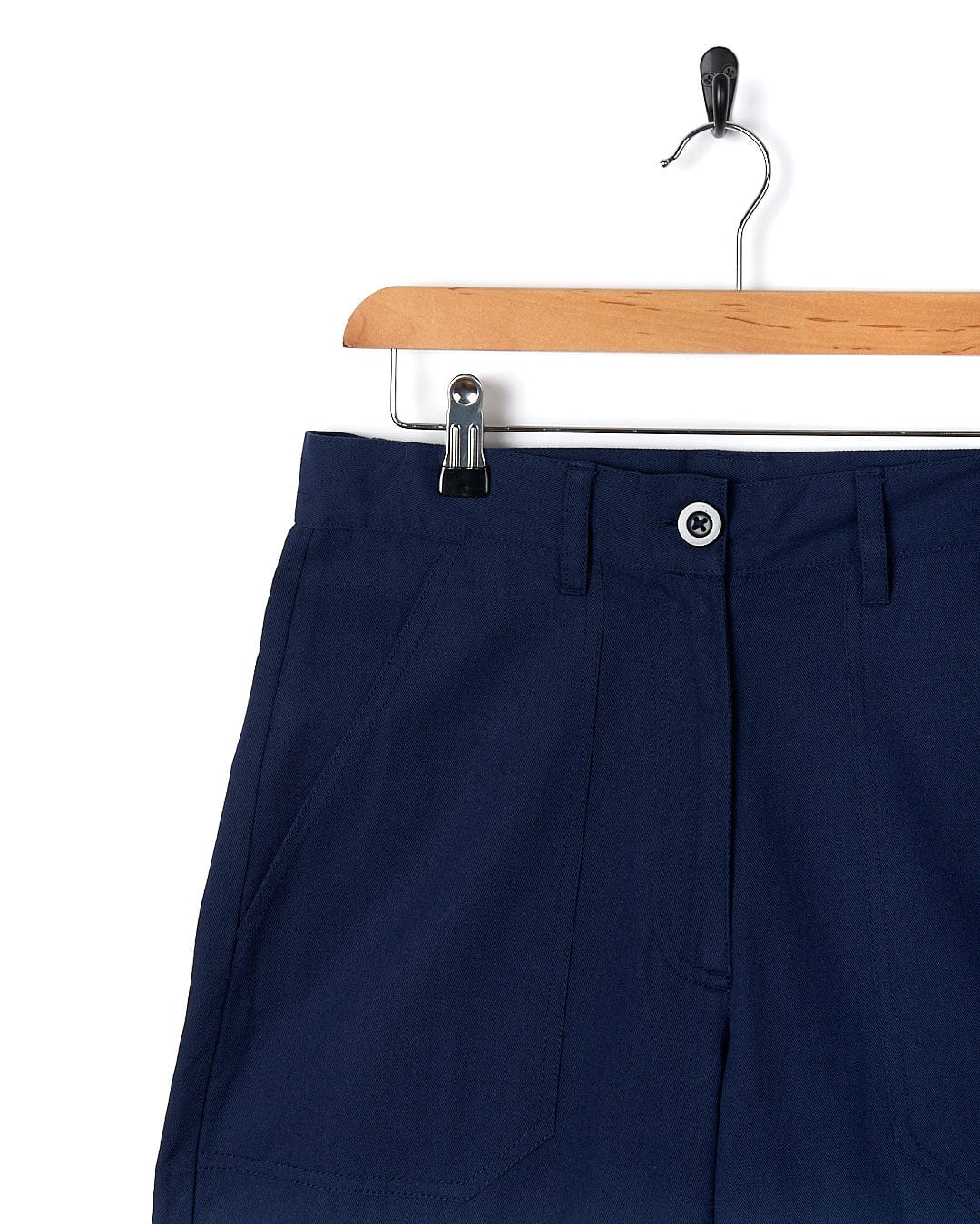 A pair of Saltrock Hilda - Womens Canvas Trouser - Dark Blue shorts hanging on a hanger.