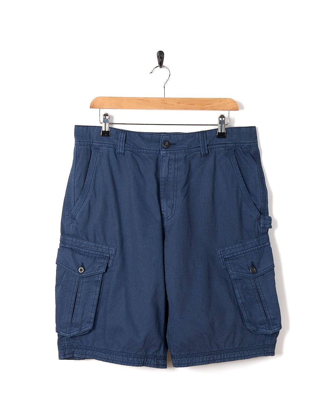 A pair of Penwith II - Mens Cargo Shorts - Blue by Saltrock, hanging on a hanger, perfect for adventuring.